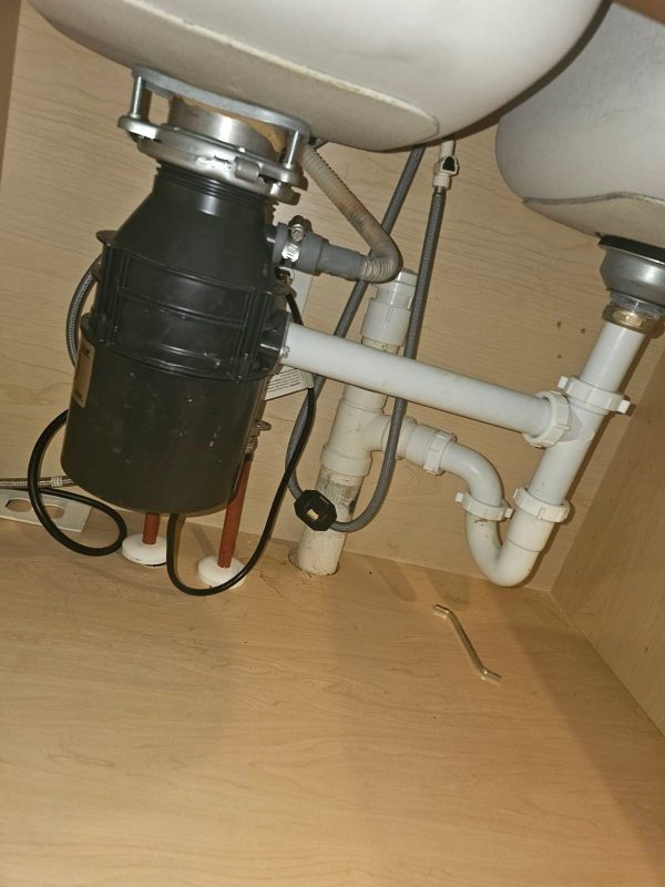 "Handyman fixing kitchen sink leak in residential home"